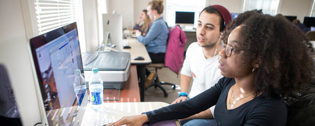 Photo of students working on computers and projects in the classroom
